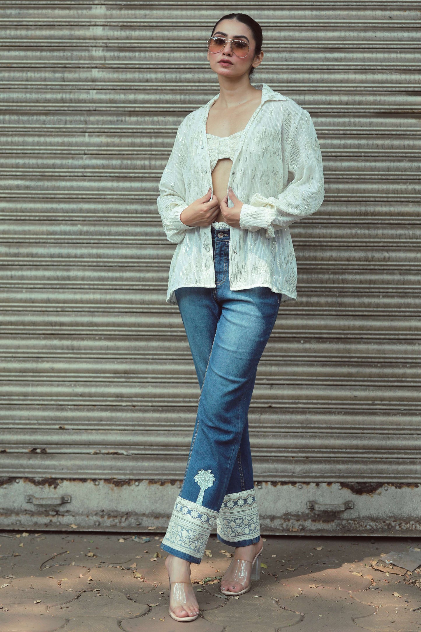 Pair of hot mess jeans by 66aura featuring distressed denim and a relaxed fit, shown hanging on a hanger.