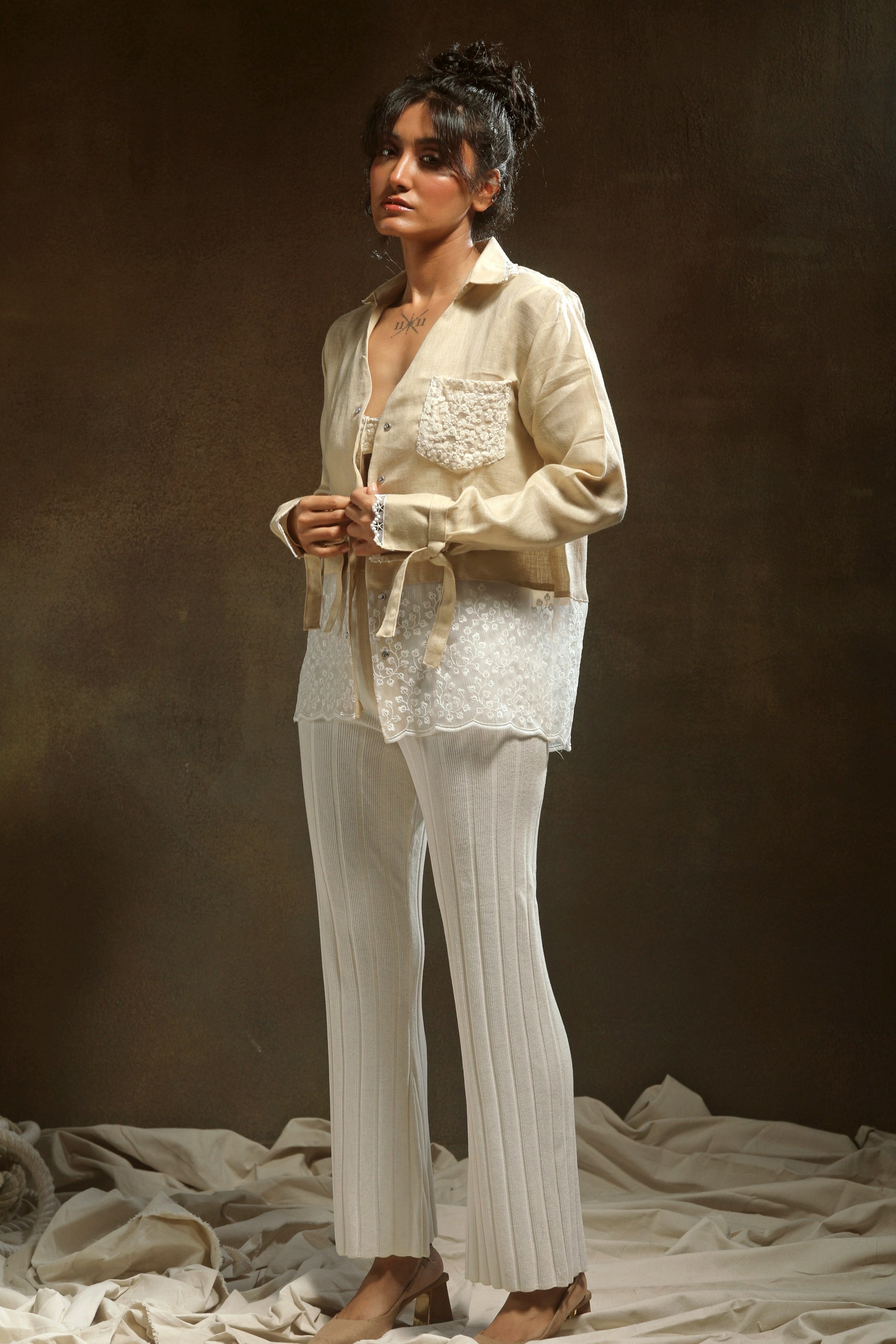 Tan oversized twist shirt by 66aura, featuring a relaxed fit and unique twist detail, displayed on a hanger against a neutral background.