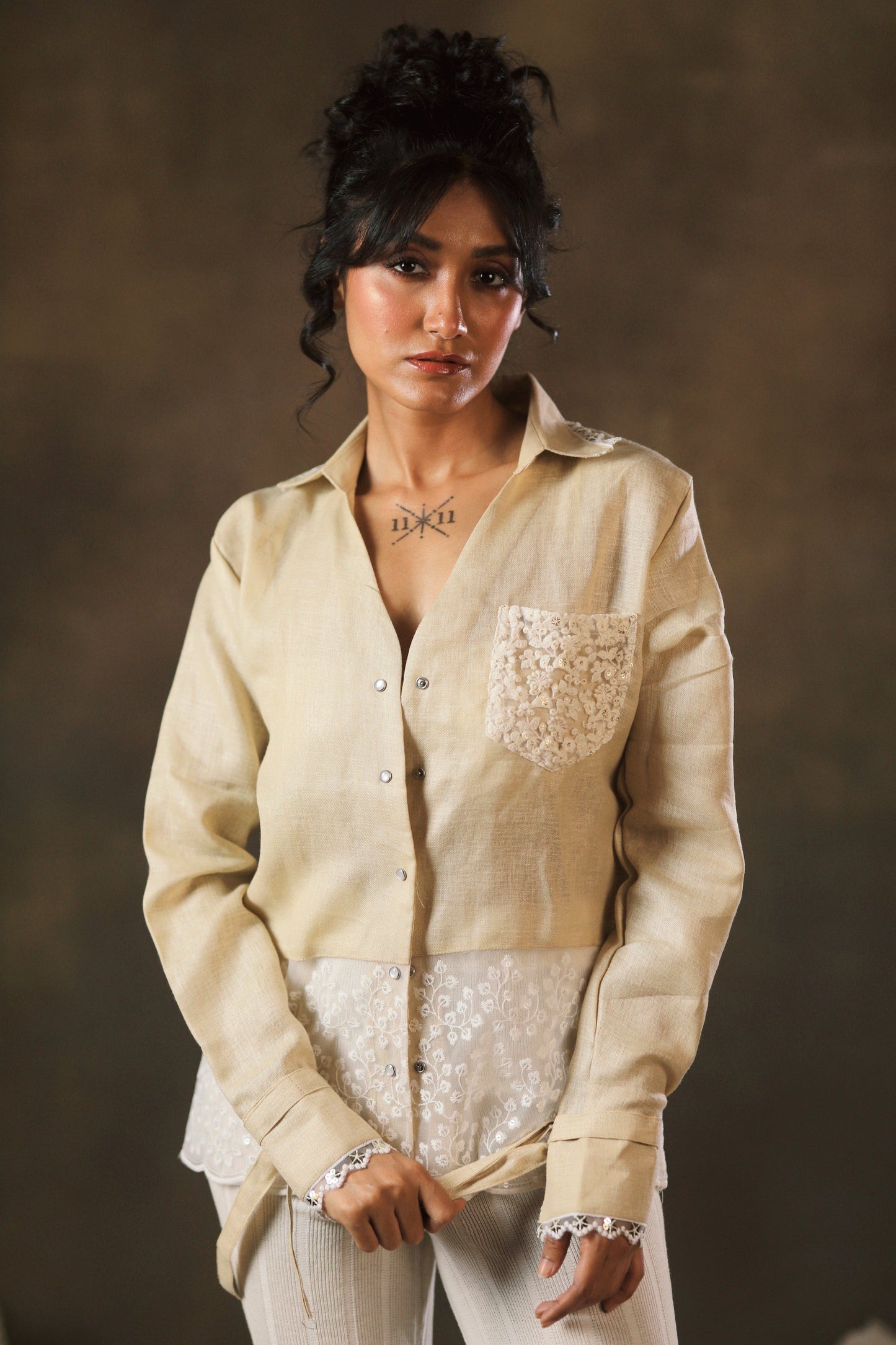 Tan Twist oversized shirt by 66aura, featuring a relaxed fit with twisted front design and long sleeves, displayed on a hanger.