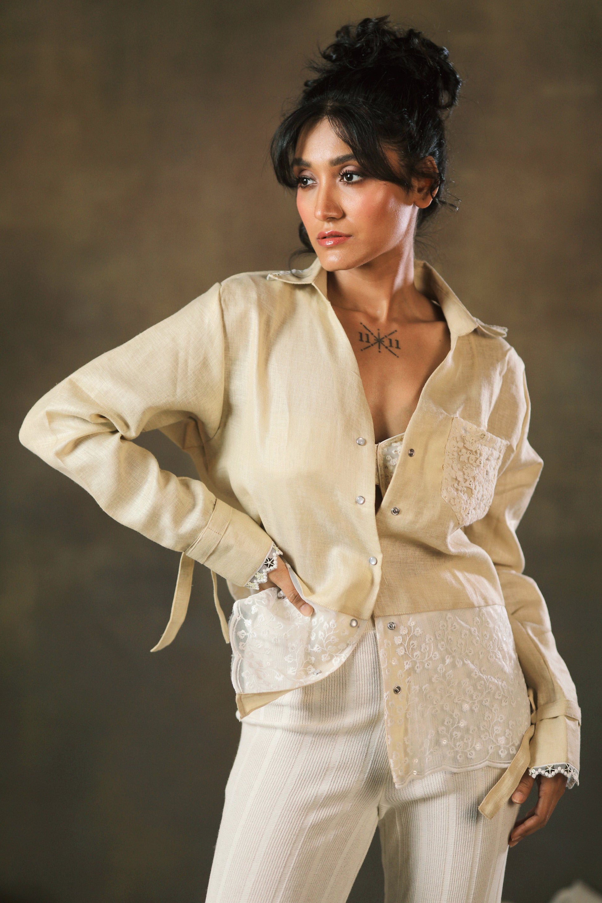 Tan oversized twist shirt by 66aura, featuring a relaxed fit and twisted front design, shown on a neutral background.