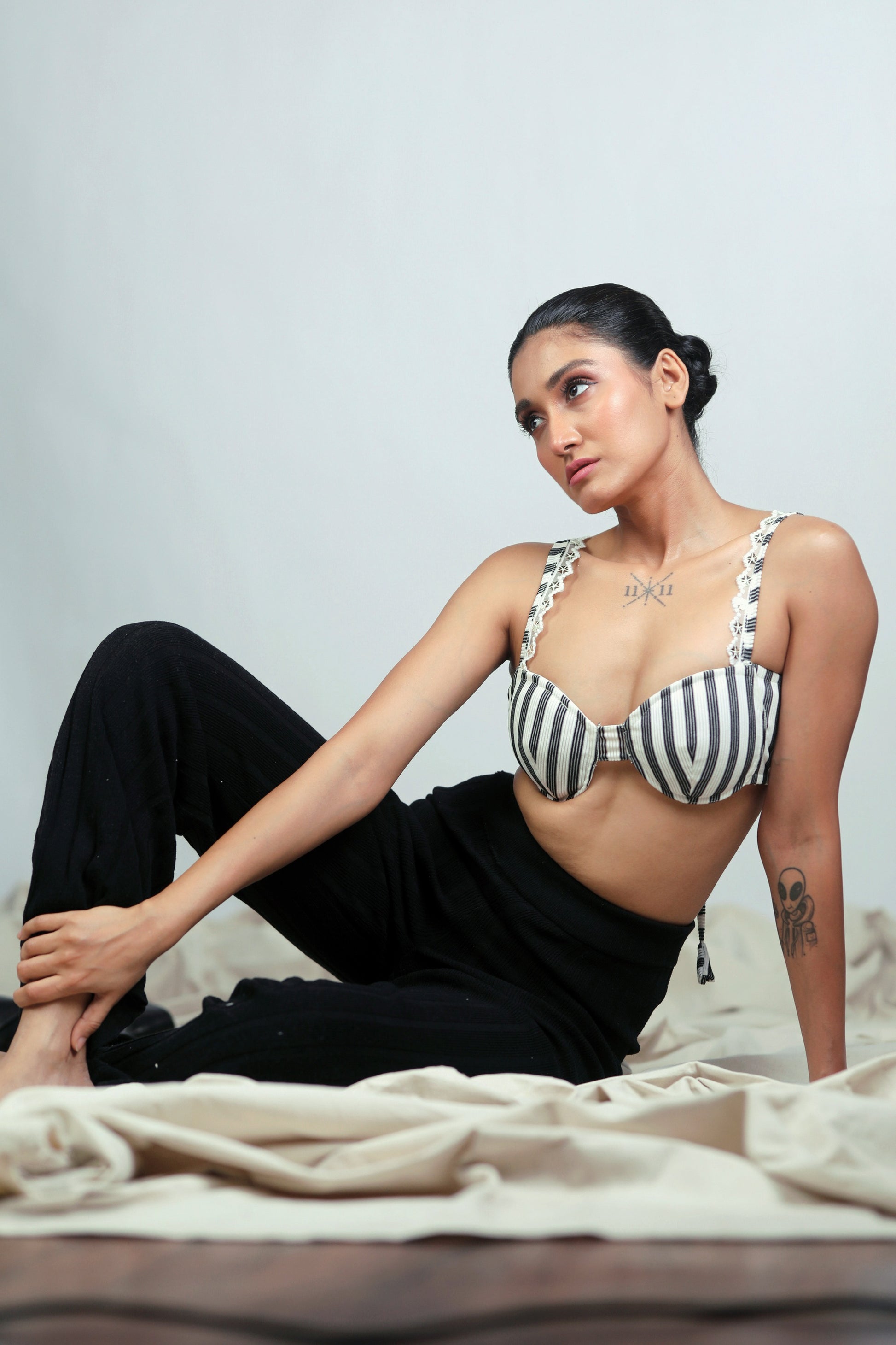 66aura Power Pinstripe Bralette showing black and white striped fabric with adjustable straps and a comfortable fit.