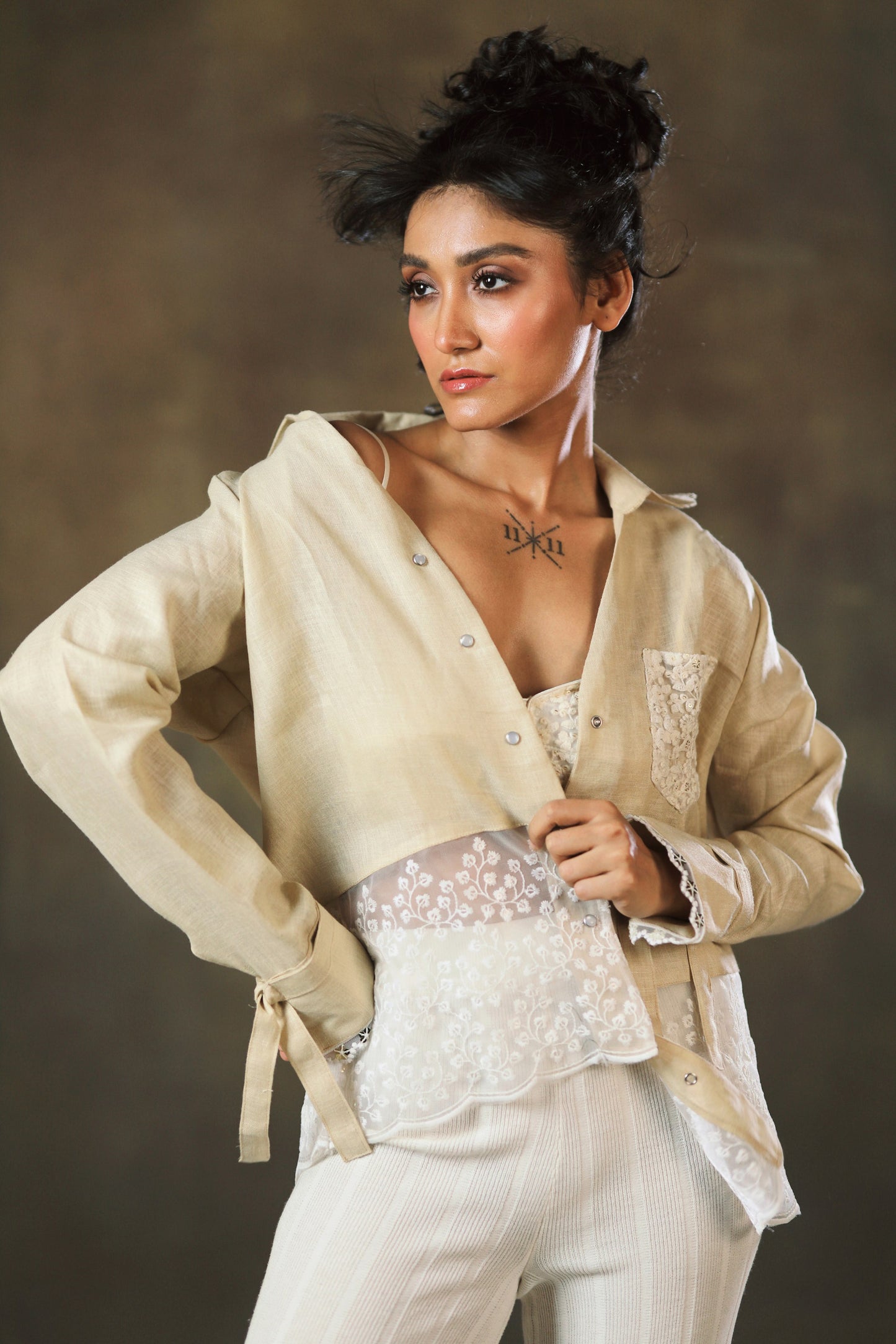 Tan Twist oversized shirt by 66aura, featuring a relaxed fit with twist detailing and long sleeves, displayed on a hanger.