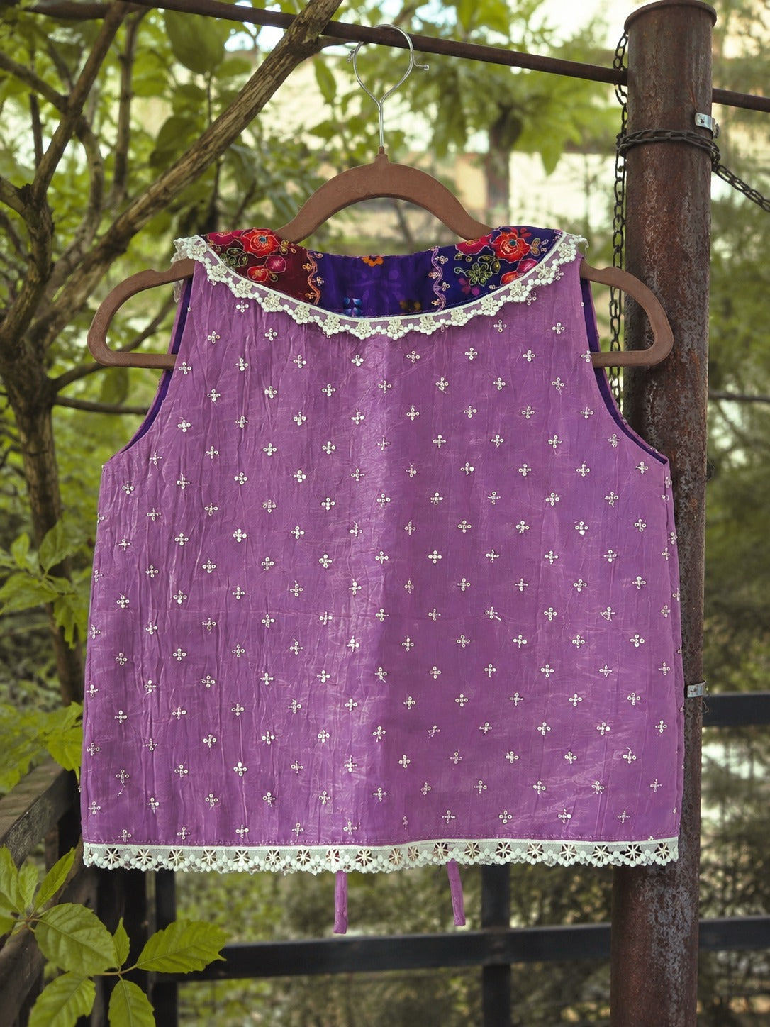 66aura Paris Poise Top in elegant fabric with a stylish neckline, displayed on a hanger against a neutral background.