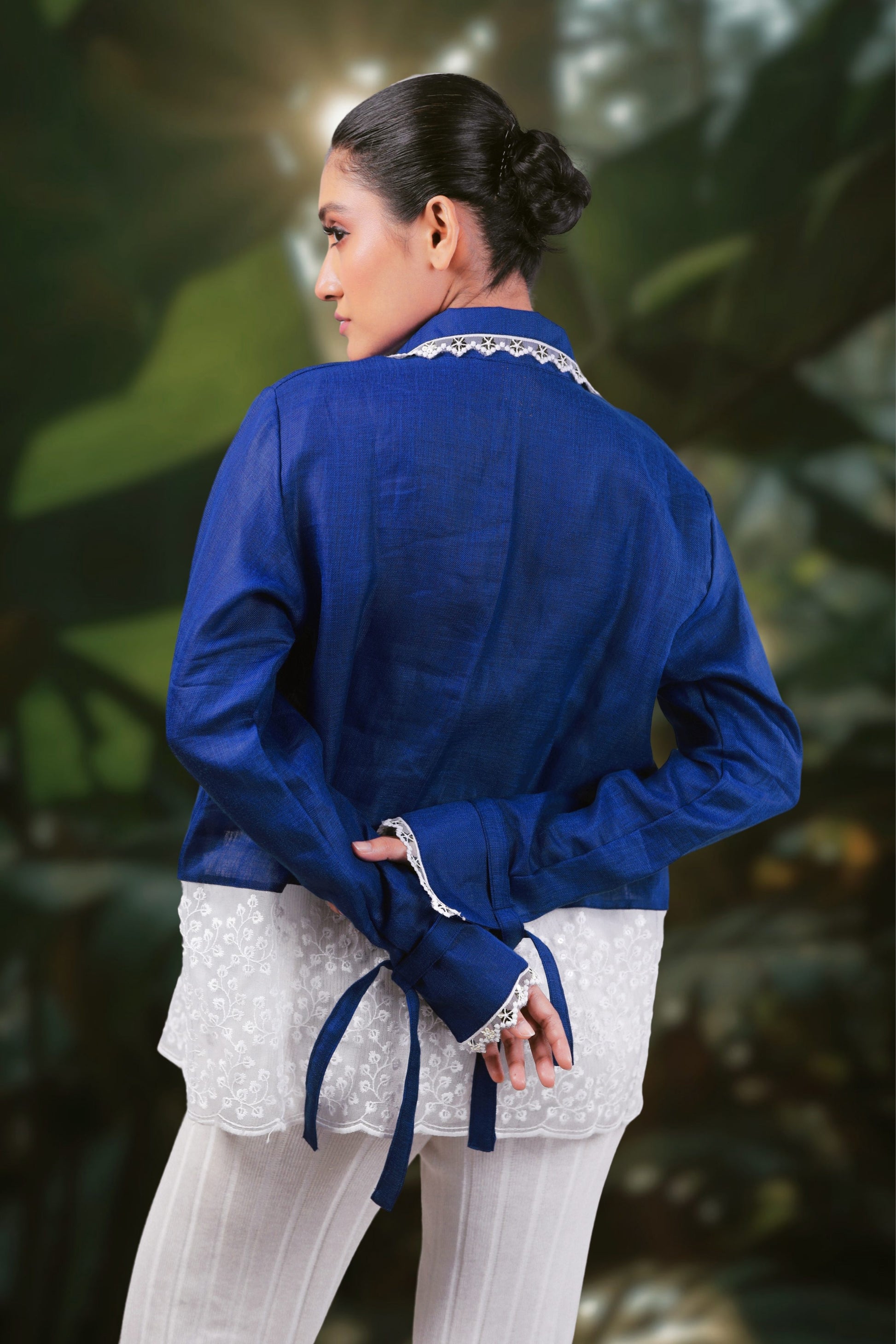Model wearing a cobalt crush oversized shirt from 66aura, standing on a carpeted floor with a decorative prop.