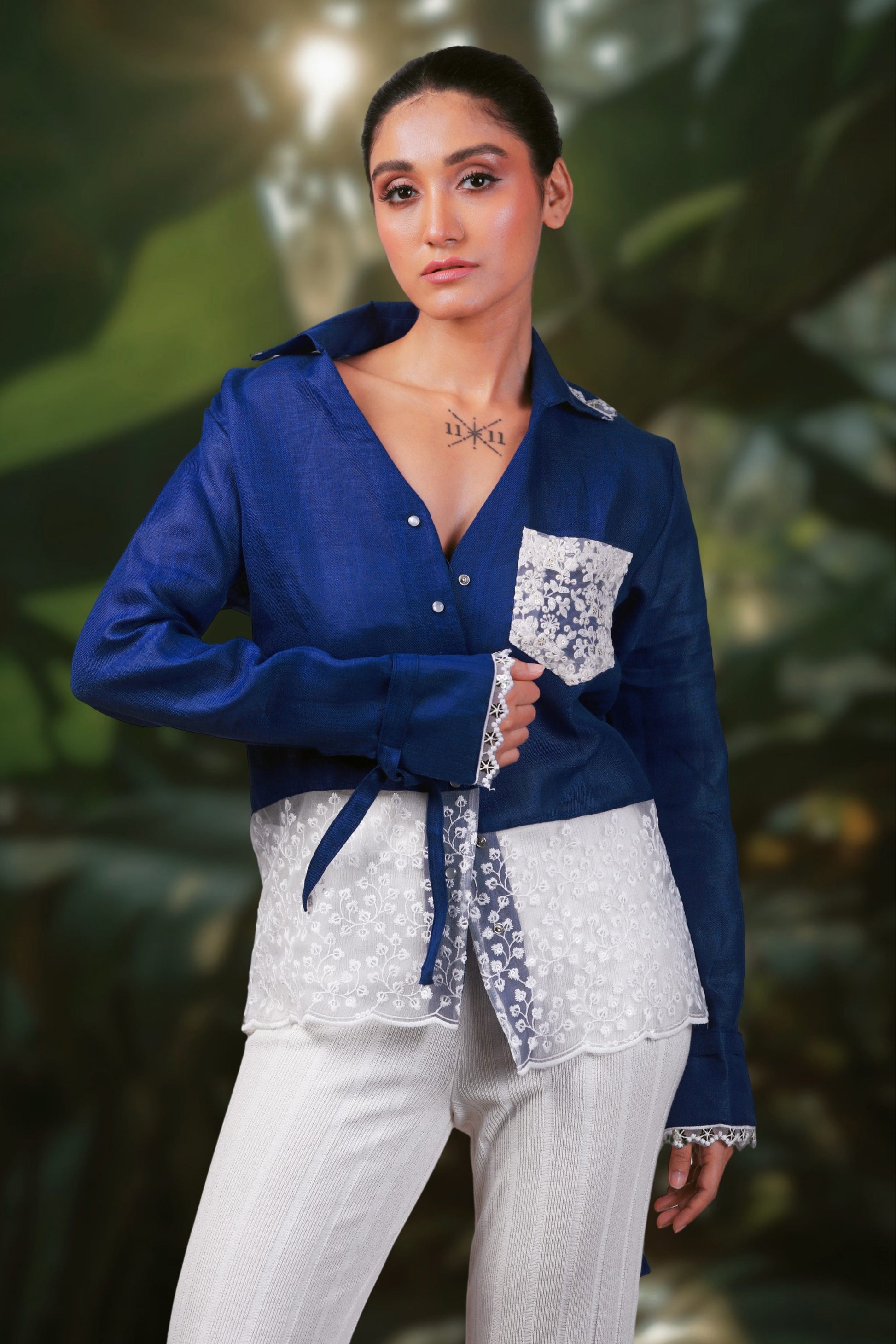 Model wearing a cobalt crush oversized shirt by 66aura, shown in a styled photo with a carpet and prop background.