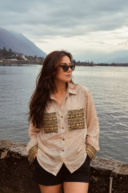 Model wearing 66aura Ethnic Echo oversized shirt, featuring vibrant patterns, relaxed fit, and stylish details on a textured background.