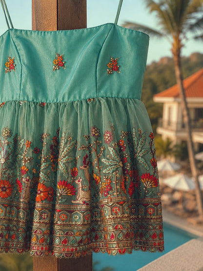 Light blue Cannes Coast top by 66aura displayed hanging against a neutral background, showcasing its relaxed, casual style.