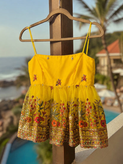 Yellow Malibu Morning Top by 66aura displayed hanging on a wooden hanger, showcasing its vibrant color and casual style.