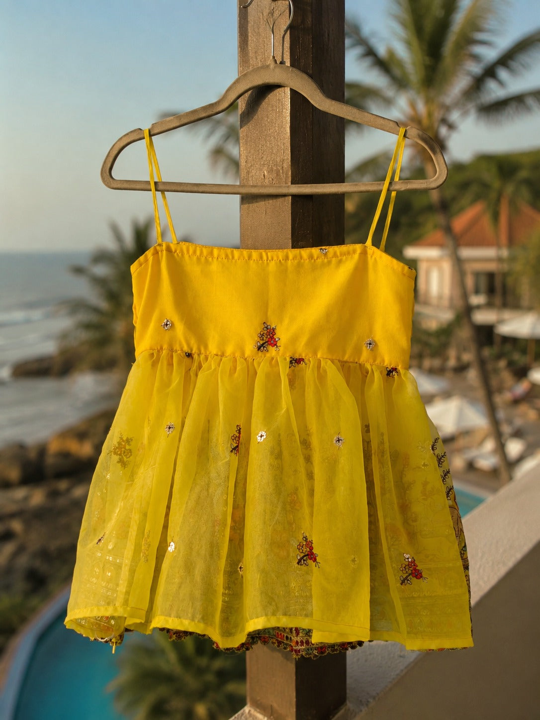 Yellow Malibu Morning Top by 66aura displayed hanging on a wooden rack with a relaxed, summery vibe.